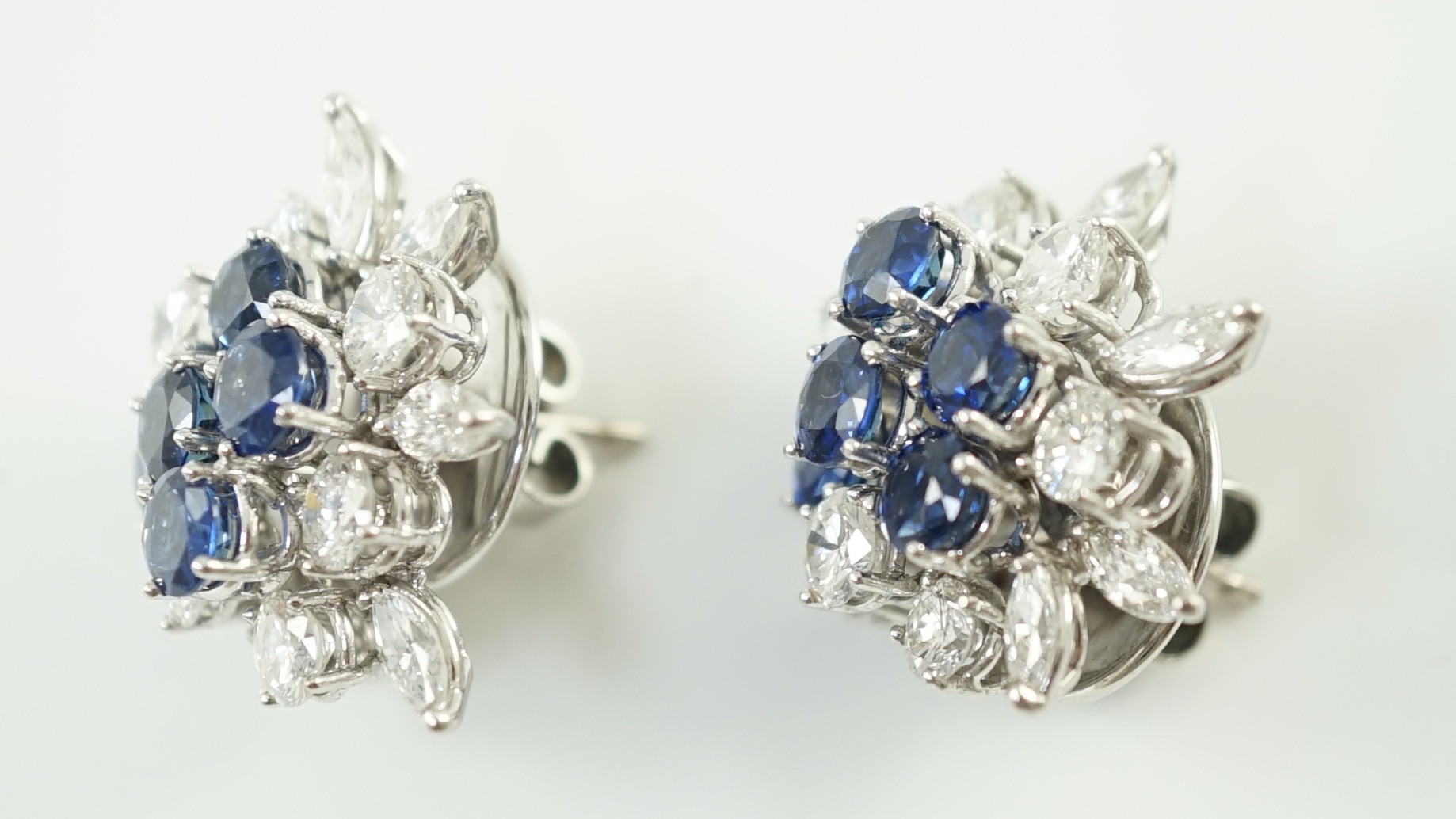 A pair of modern 750 white gold, set sapphire and diamond cluster ear studs